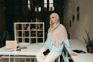 moderno muçulmano mulher dentro hijab dentro escritório quarto foto