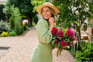 lindo jovem mulher dentro verão estilo equipamento sorridente feliz caminhando com flores dentro cidade rua foto