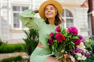 lindo jovem mulher dentro verão estilo equipamento sorridente feliz caminhando com flores dentro cidade rua foto