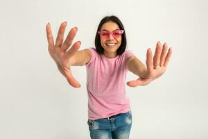 atraente mulher dentro Rosa camiseta e oculos de sol foto