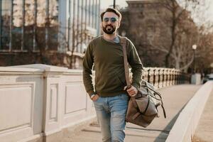 hipster homem caminhando dentro rua com saco foto