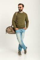 atraente à moda homem viajante em pé com saco foto