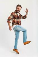 bonito barbudo homem dentro hipster equipamento vestido dentro jeans e xadrez camisa foto
