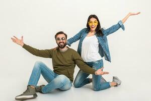 à moda casal sentado em chão dentro jeans foto