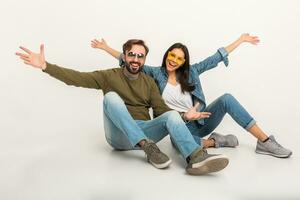 à moda casal sentado em chão dentro jeans foto