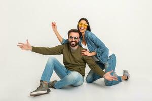 à moda casal sentado em chão dentro jeans foto