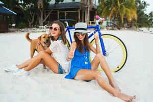 feliz fêmea amigos tendo Diversão em tropical de praia foto