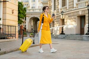 à moda mulher viajando com amarelo mala de viagem dentro Europa foto