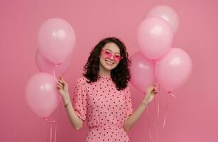 bonita jovem mulher posando isolado em Rosa estúdio fundo com Rosa ar balões foto