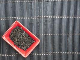chá chinês em uma pequena placa vermelha. vista de cima de cima com espaço de cópia foto