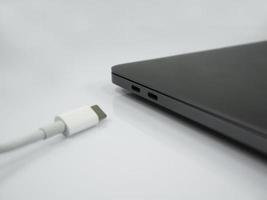 cabo tipo c e laptop no fundo branco foto