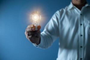 empresário de mão segurando lâmpada, conceito de inovação e inspiração foto