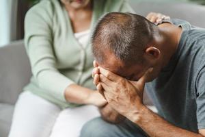 amiga ou família sentada e de mãos dadas durante animar o homem deprimido mental, o psicólogo fornece ajuda mental ao paciente. conceito de saúde mental ptsd foto