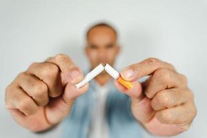 mão de homem esmagando cigarro, conceito de parar de fumar, mundo sem dia de tabaco. foto