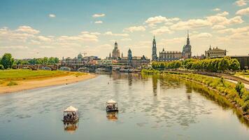 Dresden, Alemanha. panorama com velho cidade histórico centro da cidade, Elba rio e festa barcos com jovem pessoas a comemorar quente verão dia foto