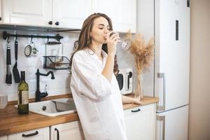 jovem mulher com um copo de vinho em casa. foto