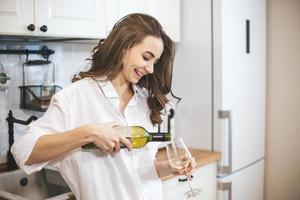jovem mulher com um copo de vinho em casa. foto