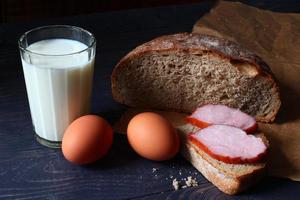comida rústica simples. ovos, pão, leite e presunto. foto
