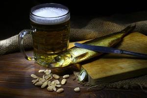 comida masculina. peixe defumado e uma caneca de cerveja. foto