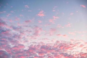 nuvens rosas coloridas no céu azul ao entardecer foto