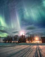 aurora boreal sobre igreja cristã com a lua