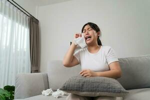 retrato do uma triste ásia mulher chorando lenços dela lágrimas com uma lenço de papel papel toalha. foto