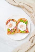 pão integral torrado com vegetais, bacon e ovo ou ovo benedict, no café da manhã foto