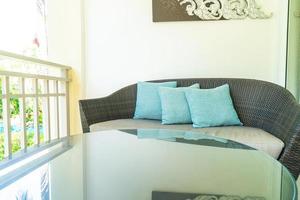 decoração de travesseiro confortável em cadeira de pátio na varanda foto
