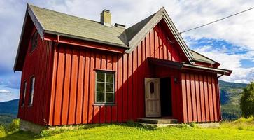 bela cabana de madeira vermelha cabana na colina na natureza da Noruega. foto