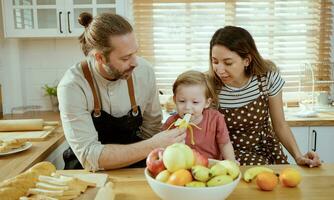 feliz família comendo frutas dentro a cozinha. foto