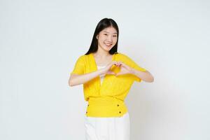 sorrindo mulher fazendo uma coração em forma gesto com dela dedos isolado em branco fundo. foto