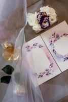 convite de casamento em um envelope cinza sobre uma mesa com ramos verdes foto