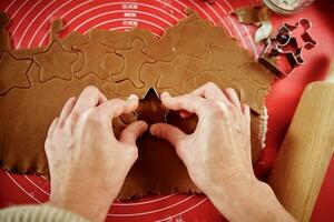 Natal cozimento. mulher cozinhando Pão de gengibre biscoitos foto