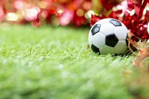 bola de futebol com decoração de natal na grama verde foto