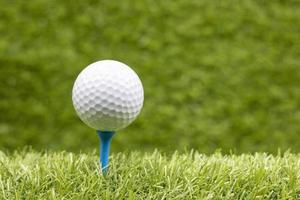 a bola de golfe com o tee está na grama verde foto