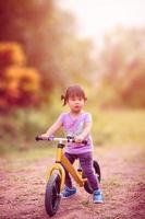 menina andando de bicicleta equilibrada no parque foto