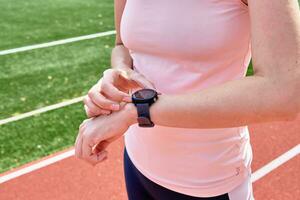 mulher usar ginástica inteligente assistir, verificação resultados depois de esporte Treinamento foto