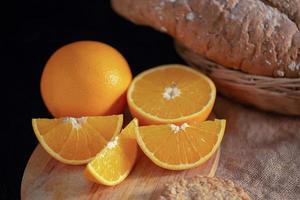 fatias de laranja e laranja na mesa de madeira foto