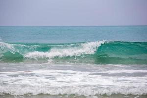 água do mar azul abstrata com ondas brancas para o fundo foto