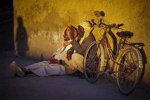 tamanrasset, argélia 2010 - pessoa desconhecida sentada com sua bicicleta foto