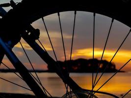 silhueta da roda da bicicleta e luz do nascer do sol foto