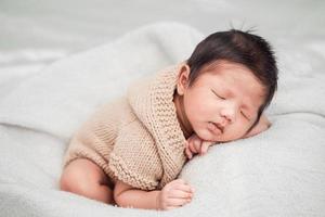 adorável bebê recém-nascido dormindo pacificamente em um cobertor branco