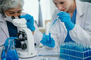 equipe fêmea cientista investigador conduzindo a experimentar trabalhando dentro a químico laboratório foto