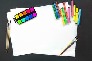 tintas, pincéis, canetas hidrográficas para desenhar com papel branco. conceito de educação, de volta à escola. espaço de cópia foto