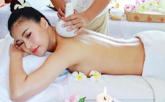 Mulher asiática feliz é tratada por massagistas profissionais em salões de spa, massagens de massagem saudável para aliviar a fadiga e relaxar foto