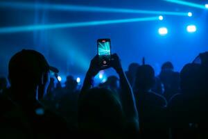 pessoas segurando inteligente telefone e gravação e fotografando dentro show , silhueta do mãos com Móvel , evento fundo conceito foto