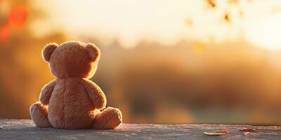 ai gerado. ai generativo. sozinho ausência de 1 brinquedo boneca pequeno Urso sentado olhando em pôr do sol fundo panorama ar livre. gráfico arte foto