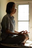 mulher budista asiática sênior praticando meditação para uma mente pacífica e vida saudável. mindfulness e conceito de religião