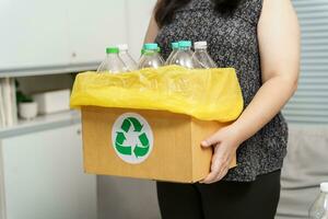 casa reciclar eco verde zero conceito mulher jogando esvaziar plástico garrafa dentro reciclando bin com amarelo lixo bolsas às lar. foto