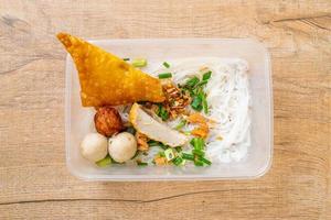 macarrão com bola de peixe e carne de porco picada na caixa de entrega - comida asiática foto